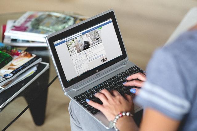 Mujer navegando por Facebook en un portátil