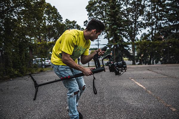 Hombre joven vlogger grabando con su cámara al aire libre