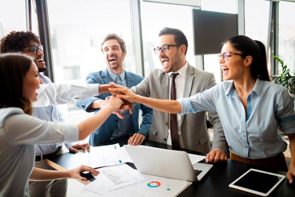 Grupo de personas que celebran el alcanzar metas en el ámbito profesional