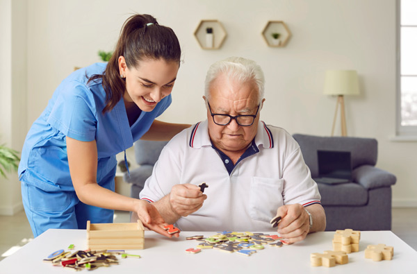 enfermera con enfermo de alzheimer practicando juegos de mesa