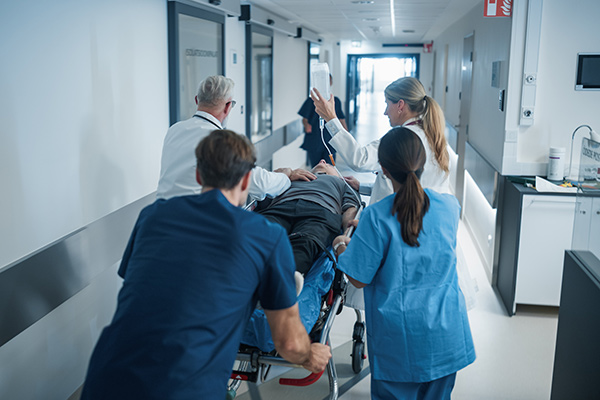 Traslado de un paciente en camilla, rodeado de dos médicos y dos auxiliares de enfermería de urgencias