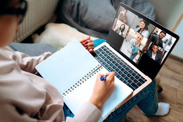 Alumno tomando apuntes durante una videoconferencia en un curso online