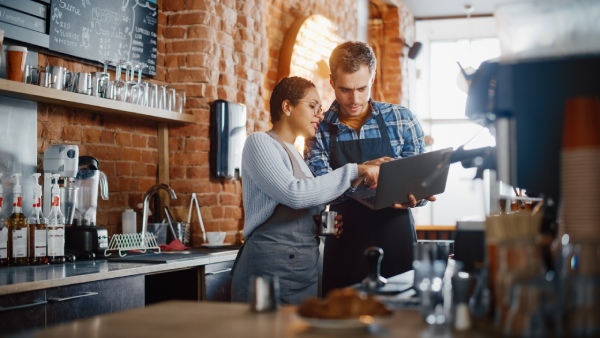 pareja de trabajadores en un bar cafetería planificando la carta del local de hostelería