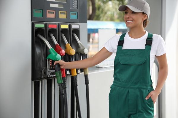 empleada de gasolinera cogiendo un surtidor