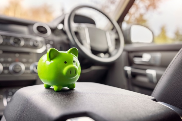 hucha cerdito de color verde en el interior de un coche