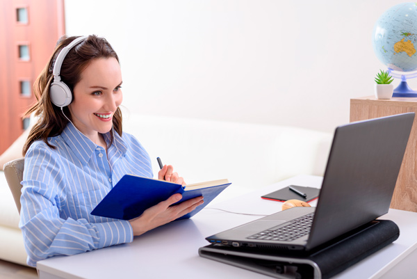 estudiante realizando un curso online con cascos y ordenador portátil