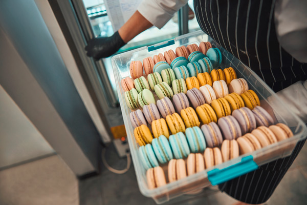 repostero con una bandeja de macarons con sabores y colores variados