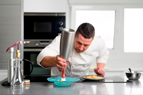 cocinero emplatando con sifón una espuma