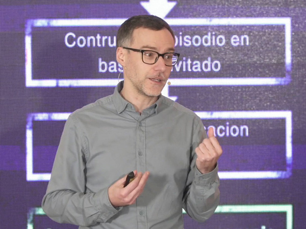 Retrato de Jesús Pérez Santiago durante una ponencia con un fondo de pantalla de luz en color violeta