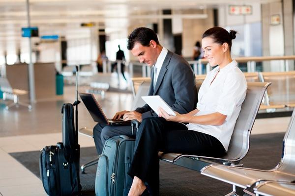 dos personas usando una wifi pública en un aeropuerto