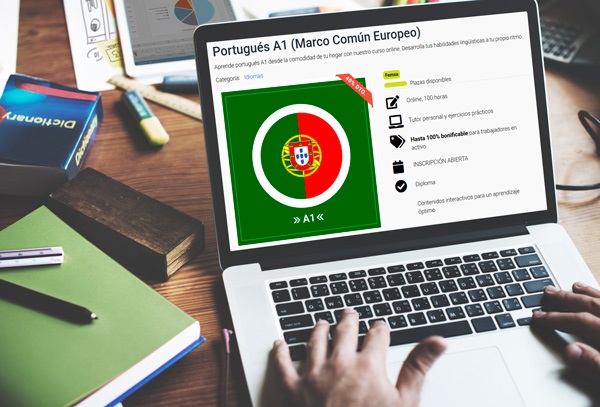 Ordenador portátil en una mesa con diccionario y elementos de escritorio, en la pantalla se ve la bandera portuguesa en el curso de idioma portugués de Femxa