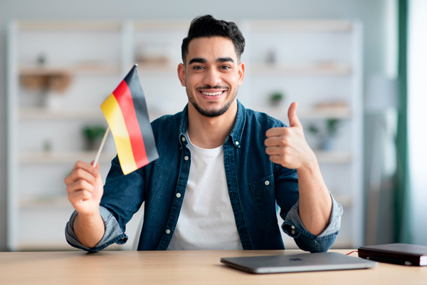 chico joven con una bandera pequeña de Alemania en la mano