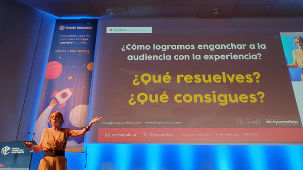 Elia Guardiola señala la pantalla de su ponencia sobre storytelling en el congreso de marketing de raiola networks