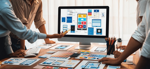Diseñadores de aplicaciones deciden funcionalidades en una pantalla de ordenador con diferentes mock up