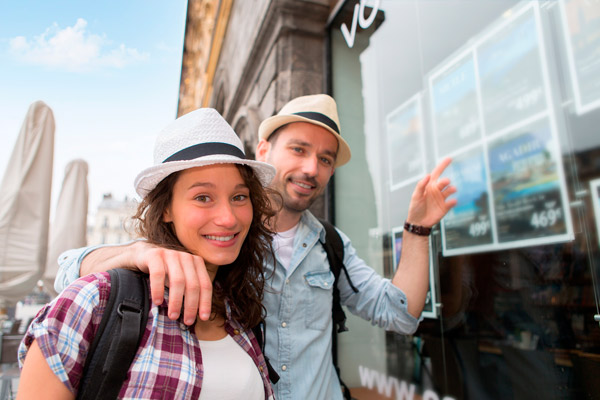 dos clientes buscando una agencia de viajes que les proporcione servicios turísticos